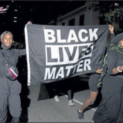 People carry a Black Lives Matter during a vigil in memory of Garrett Foster lastsunday in Austin Texas.