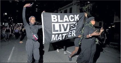 People carry a Black Lives Matter during a vigil in memory of Garrett Foster lastsunday in Austin Texas.