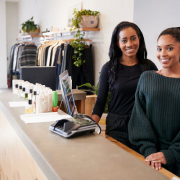 Two women smiling behind the counter