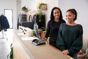 Two women smiling behind the counter